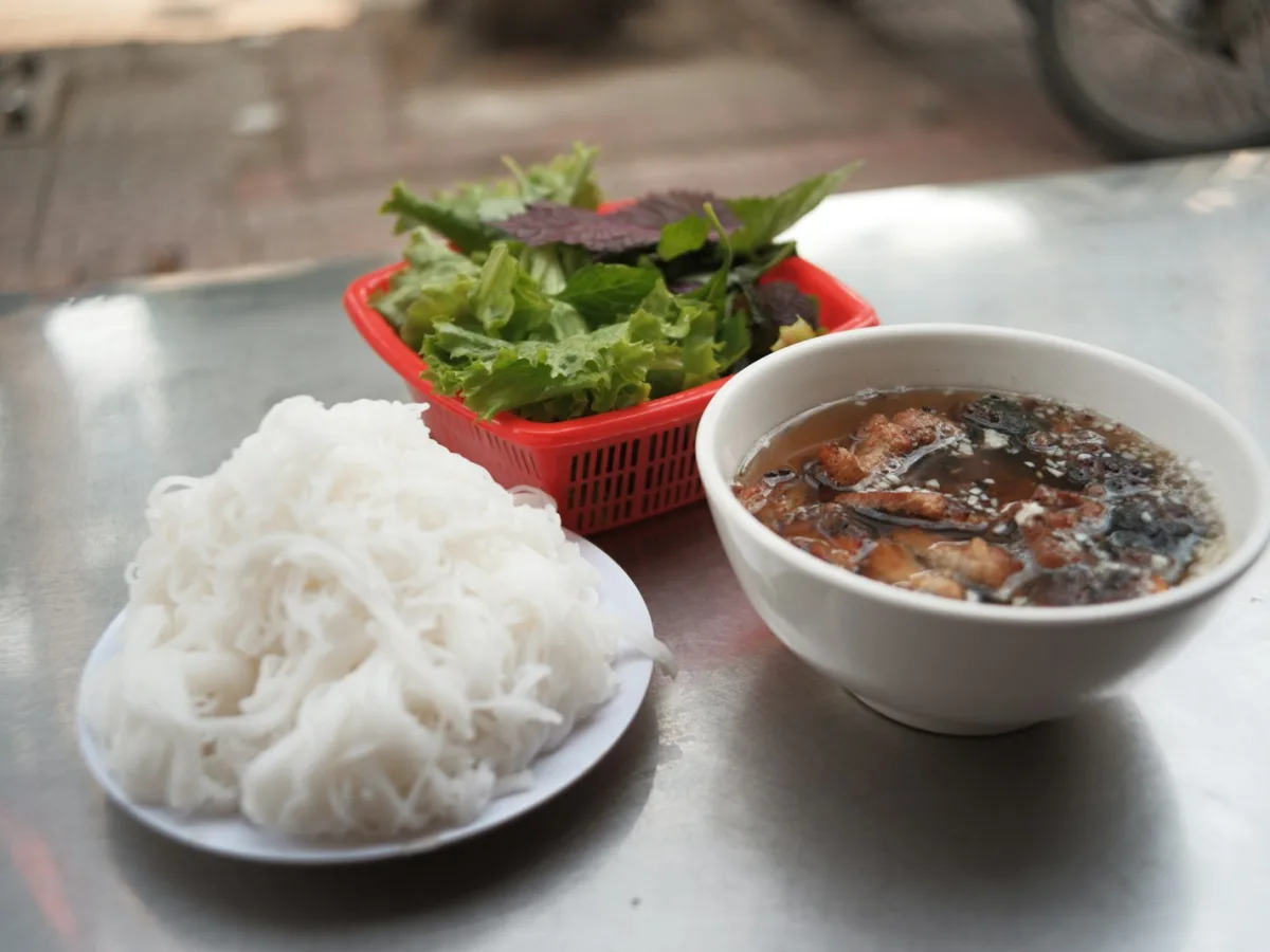 Bún, bát nước chấm có thịt nướng và rổ rau sống